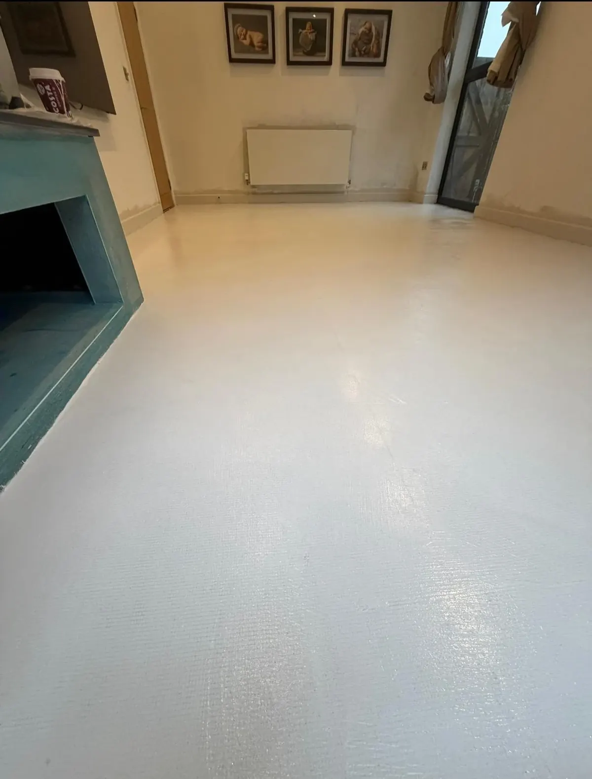Living room floor covered in a white microcement base coat with mesh texture showing